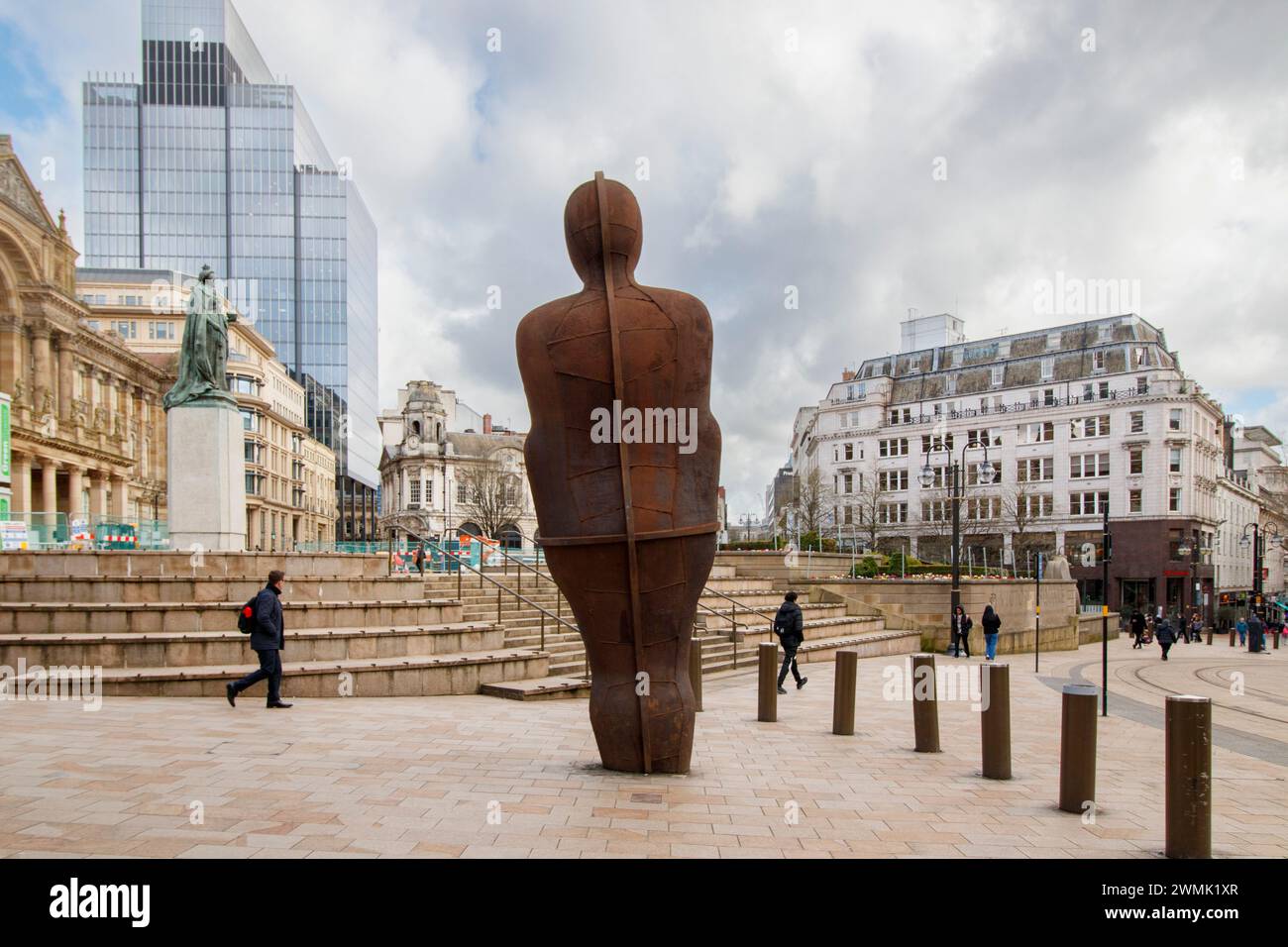 The Iron Man. The statue was reinstated to a new place in 2022 and relocated after work to install a new tramway system in Victoria Square took place. Iron:Man is a statue by Antony Gormley, in Victoria Square, Birmingham, England. The statue is 6 metres (20 ft) tall, including the feet which are buried beneath the pavement, and weighs 6 metric tons (6 long tons). The statue leans 7.5° backwards and 5° to its left.[1] It is said by the sculptor to represent the traditional skills of Birmingham and the Black Country practised during the Industrial Revolution. Stock Photo