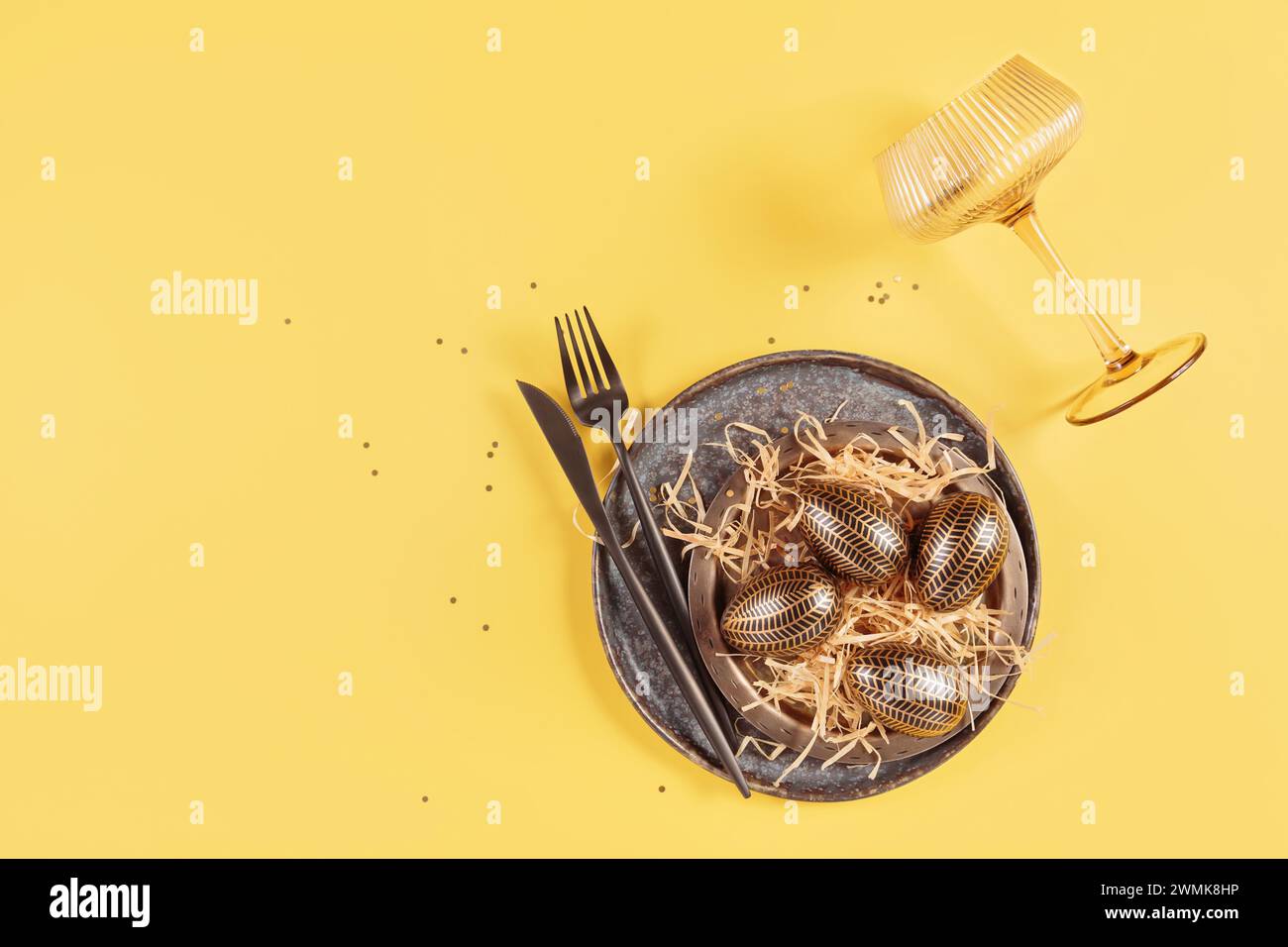 Table place setting and festive easter decor on yellow background Stock Photo