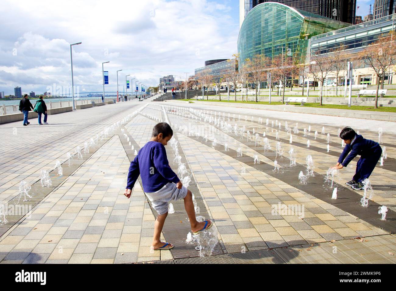 Children play in the fountains on the modern riverwalk along the Detroit River; Detroit, Michigan, United States of America Stock Photo