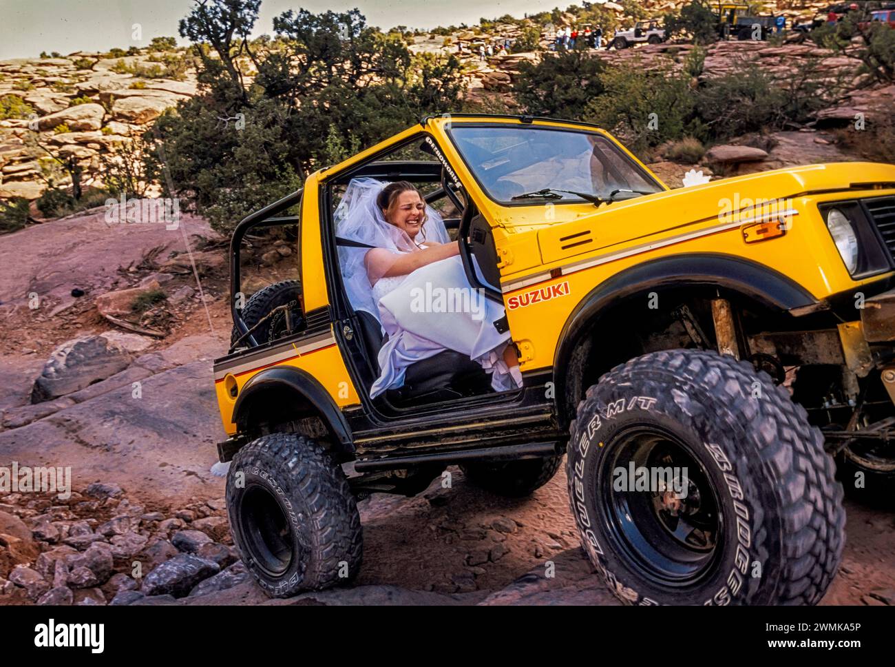 Bride hangs on for a four-wheel drive wild ride over boulders and rough slick rock trails near Moab, Utah. The Bureau of Land Managements designate... Stock Photo