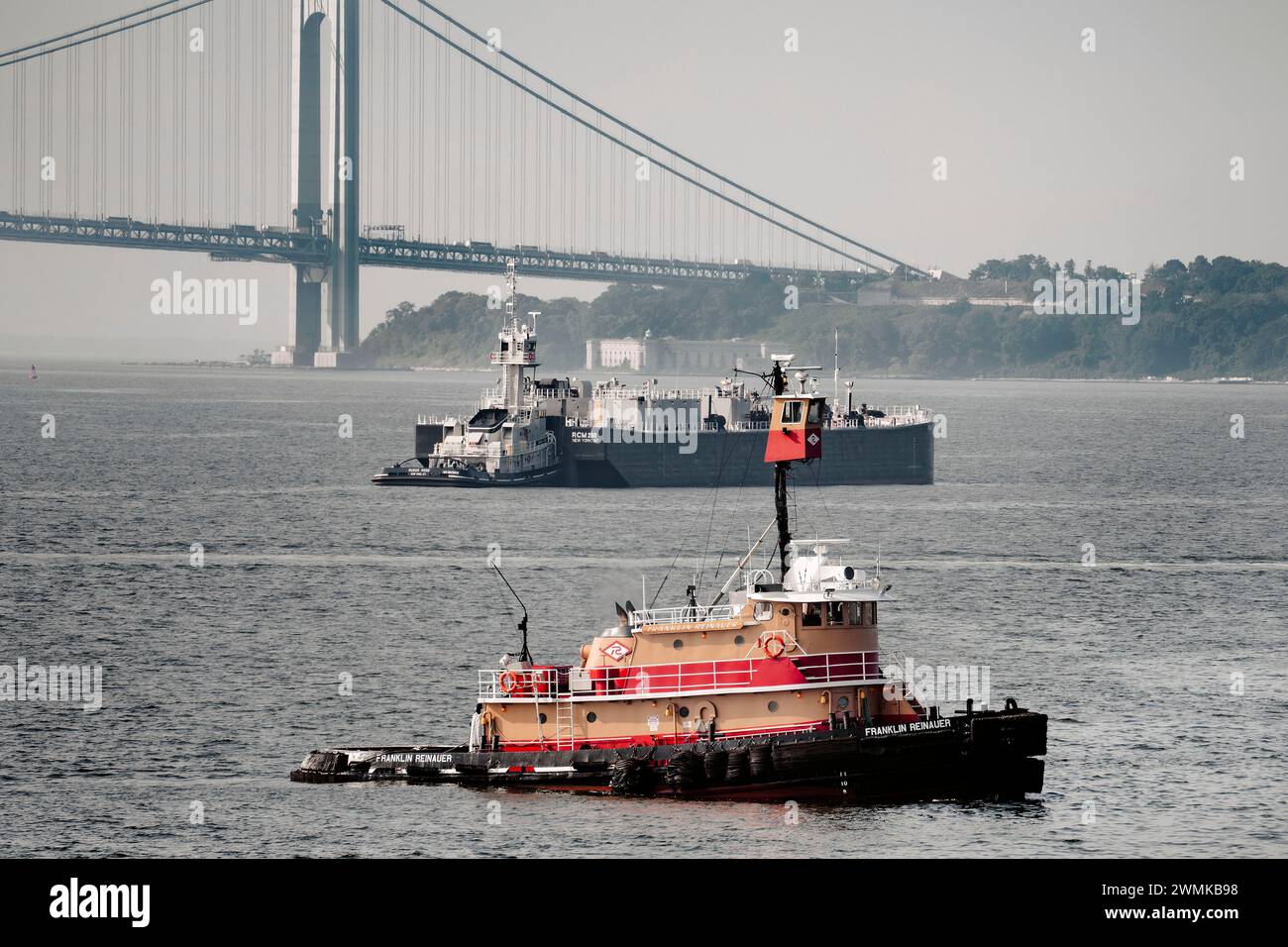 Tugboat and barge in upper New York Bay with Verrazzano-Narrows Bridge and Staten Island in background< New York City, New York, USA Stock Photo