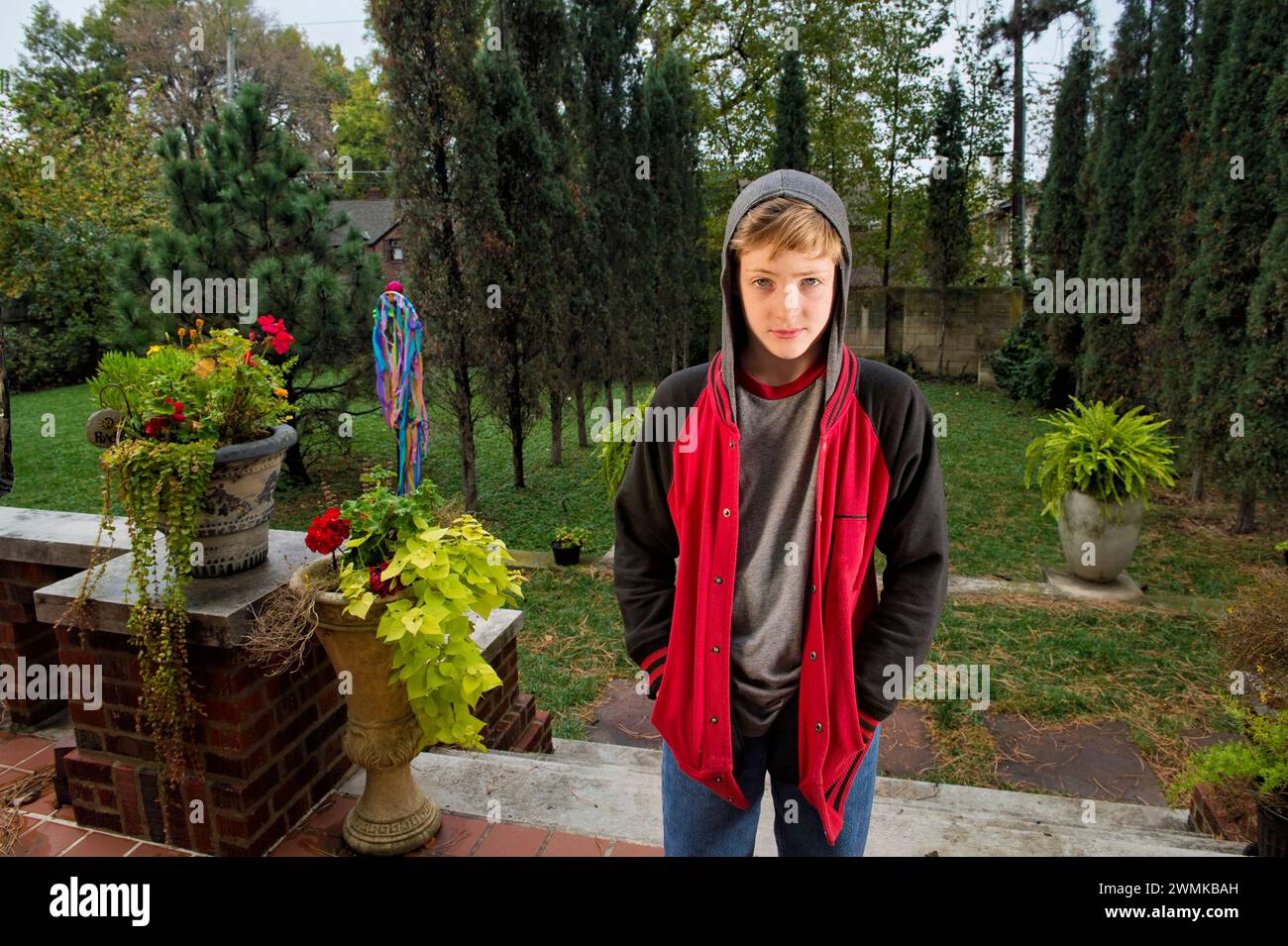 Adolescent boy wears a hooded sweatshirt; Lincoln, Nebraska, United States of America Stock Photo