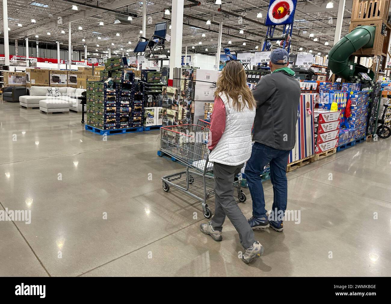 Shoppers set sail with a cart past displays of goods in a Costco ...