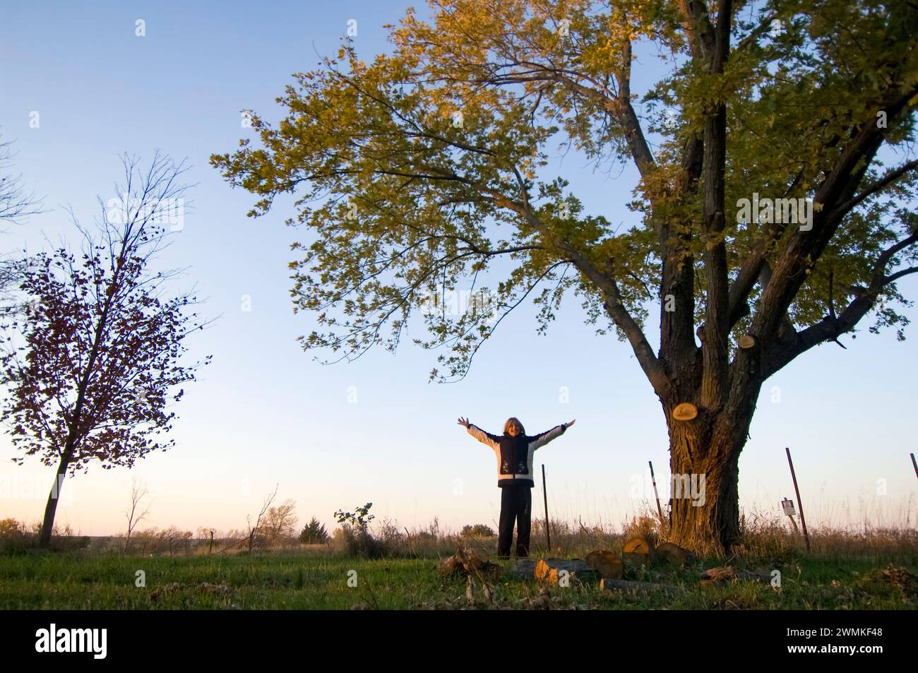 Girl stands with arms outstretched in the outdoors, a nature-lover; Princeton, Nebraska, United States of America Stock Photo