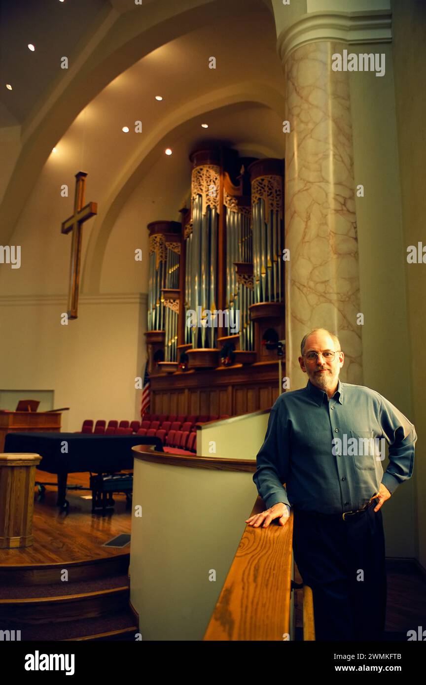Organ manufacturer in a church with one of his company's organs; Lincoln, Nebraska, United States of America Stock Photo