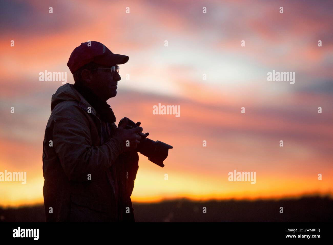 Silhouette of a man outside with a camera at sunset; Valentine, Nebraska, United States of America Stock Photo