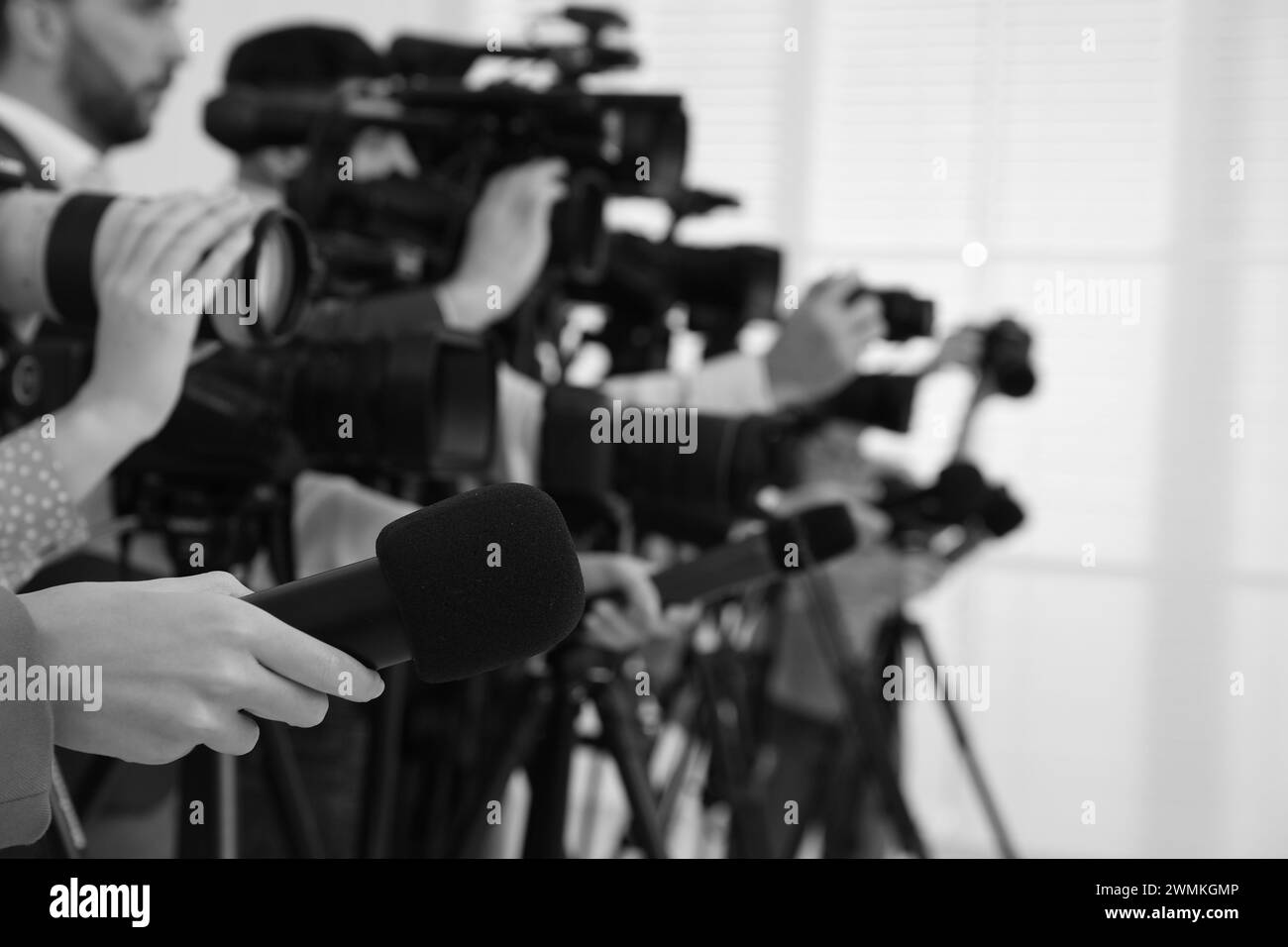 Professional journalists with microphones and cameras indoors, closeup. Black and white effect Stock Photo