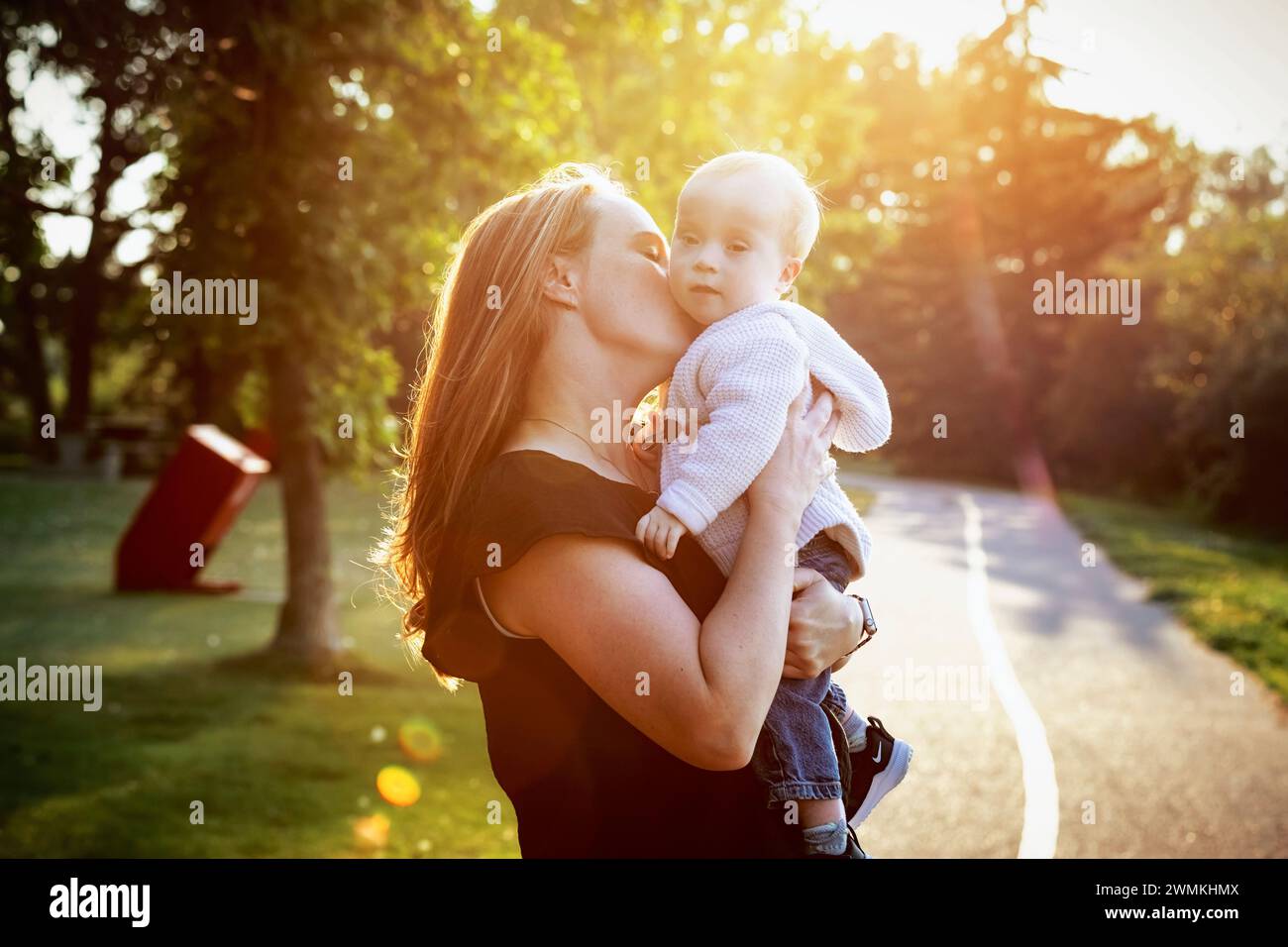 Mother spending quality time with her son who has Down Syndrome in a city park during an bright sunny autumn day; Leduc, Alberta, Canada Stock Photo