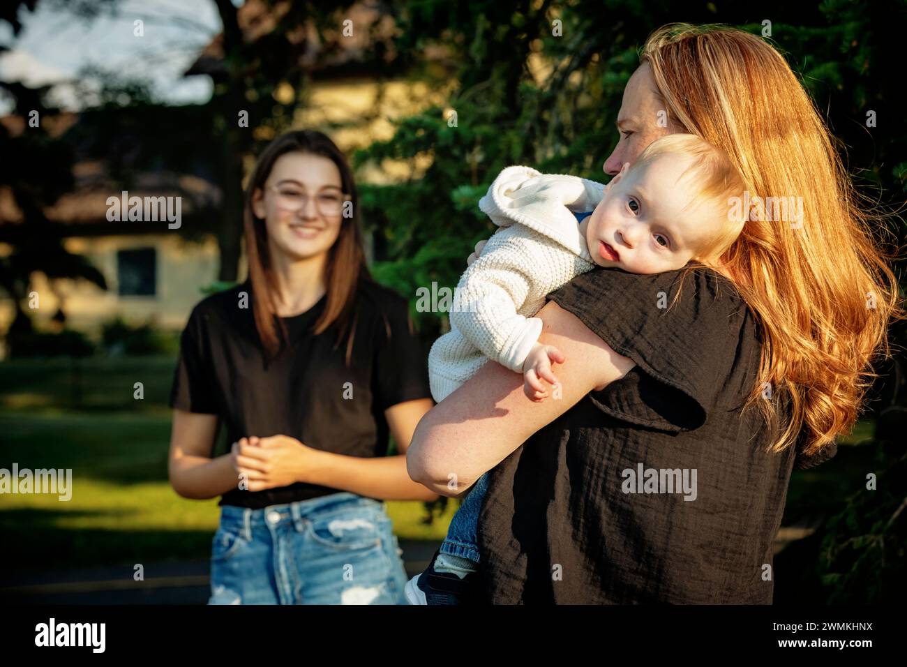 Mother spending quality time outdoors with her teenage daughter and young son who has Down Syndrome; Leduc, Alberta, Canada Stock Photo