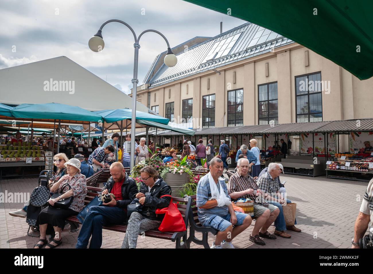 Picture of latvians, latvian people, sitting on benches by the market of centraltirgus, the riga central market. Stock Photo