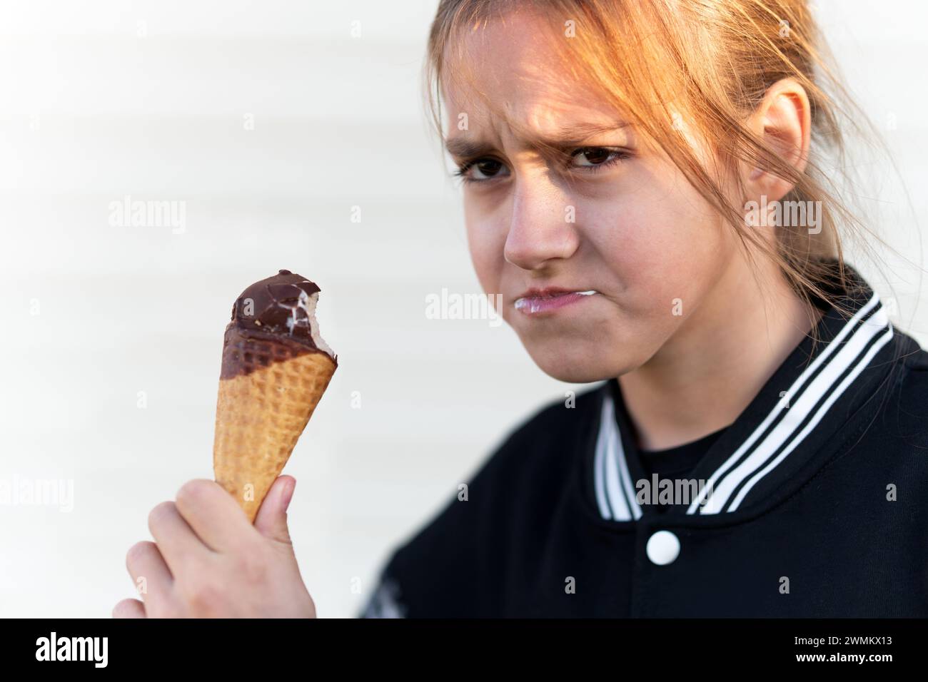 An unhappy child holding an empty ice cream cone. Tasteless ice cream Stock Photo
