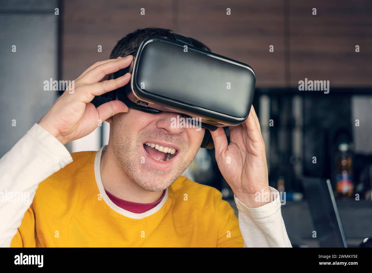 People and technology metaverse concept. Portrait of happy young handsome man, positive smiling guy using, wearing a modern device virtual reality hea Stock Photo