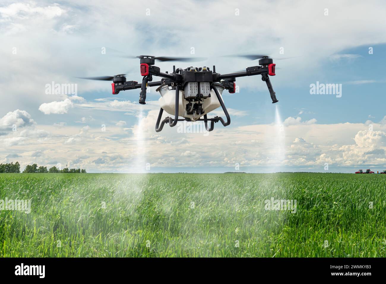 Modern technologies in agriculture. industrial drone flies over a green field and sprays useful pesticides to increase productivity and destroys harmf Stock Photo