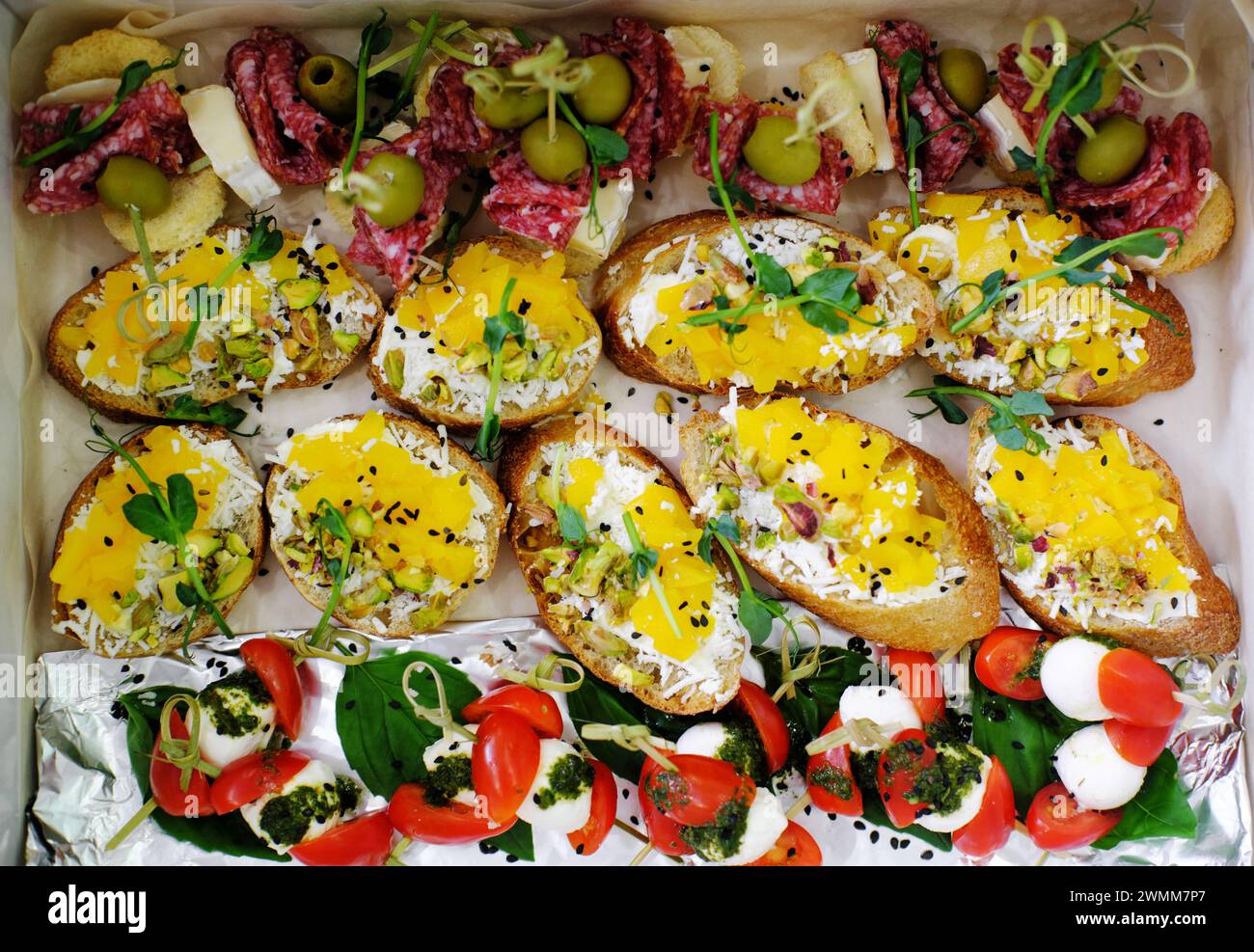 An array of bruschetta topped with avocado and cheese, alongside ...