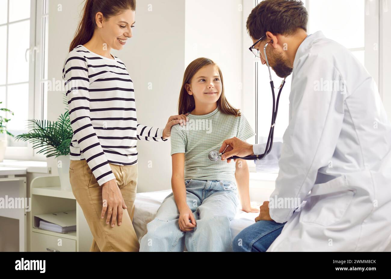 Pediatrician or family practitioner with stethoscope examines lungs or ...