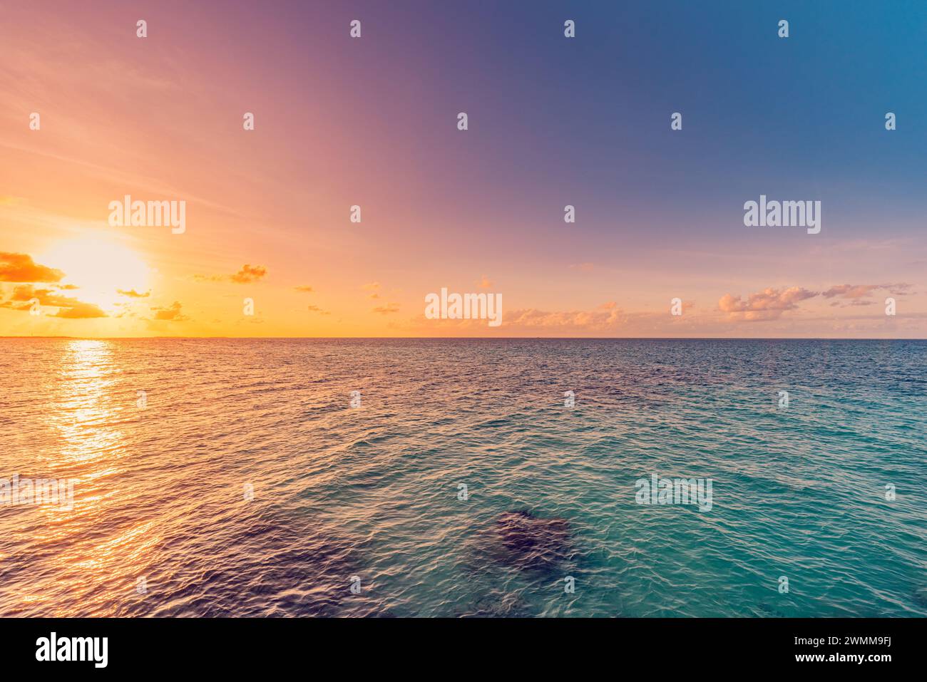 Sea sky clouds, horizon, horizontal background banner. Colorful sunset over evening sea horizon, clouds sky. Tranquil scene. Natural background Stock Photo