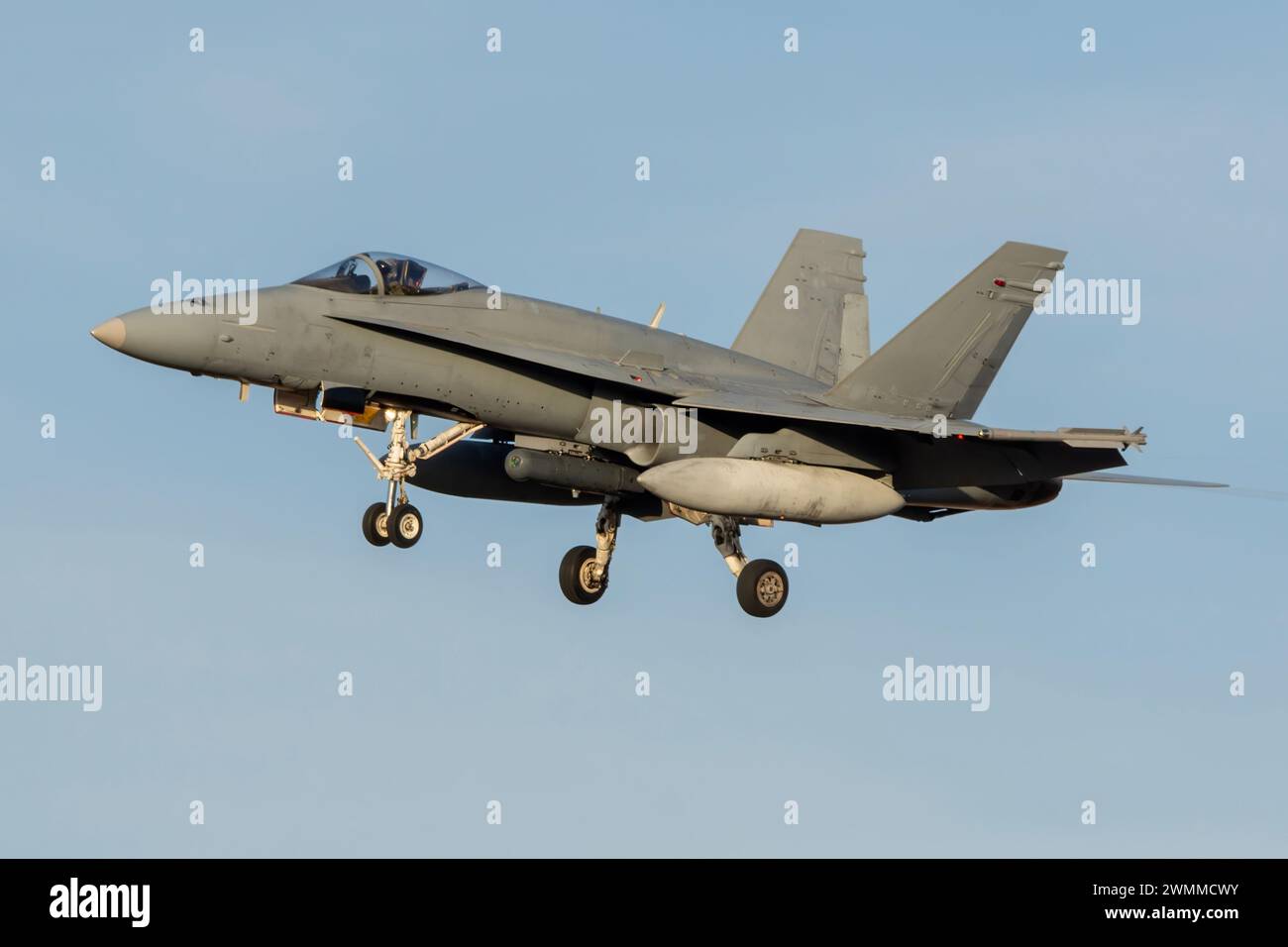 F-18 Hornet fighter jet landing at sunset Stock Photo