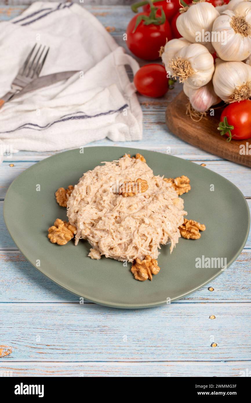 Circassian chicken dish. Appetizer dishes. Salad with flour, walnuts and chicken on a blue wooden background. local name çerkez tavuğu Stock Photo