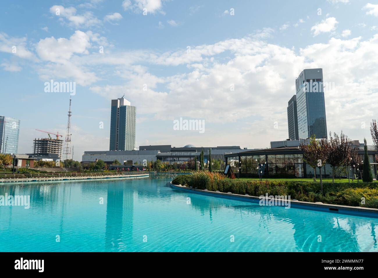 Awesome view of contemporary buildings reflected in pool of Tashkent City Park in Tashkent, Uzbekistan. park is a popular recreational gathering place Stock Photo