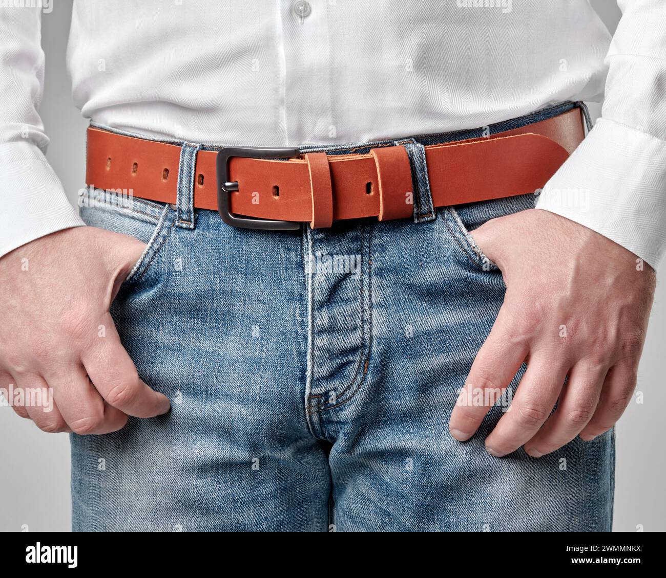 Casual male look completed with handmade brown genuine leather belt featuring embossed DAD customization, merging personal style with artisan quality Stock Photo