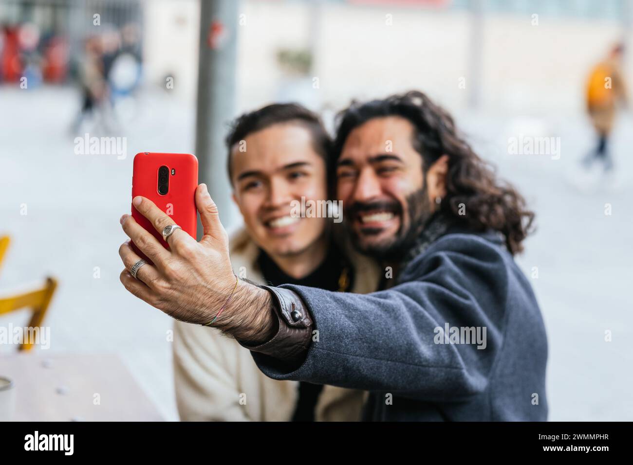 Happy gay couple in love taking a selfie with a mobile phone outdoors ...