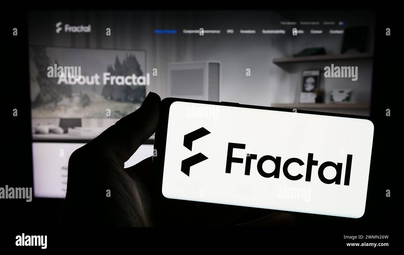 Person holding smartphone with logo of Swedish computer hardware design company Fractal Gaming AB in front of website. Focus on phone display. Stock Photo