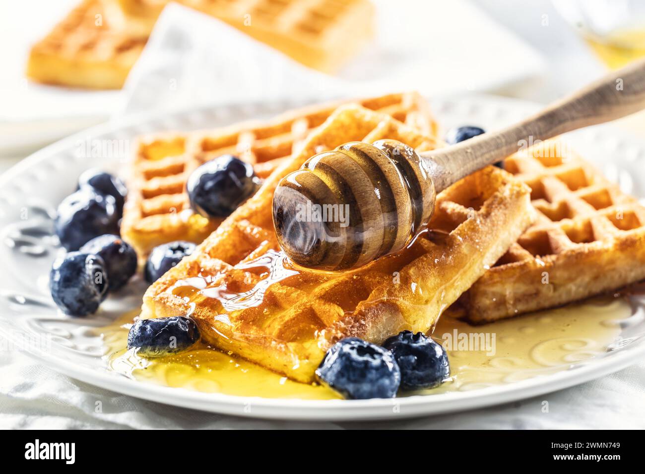 Sweet and very tasty waffles with honey and blueberries. Stock Photo