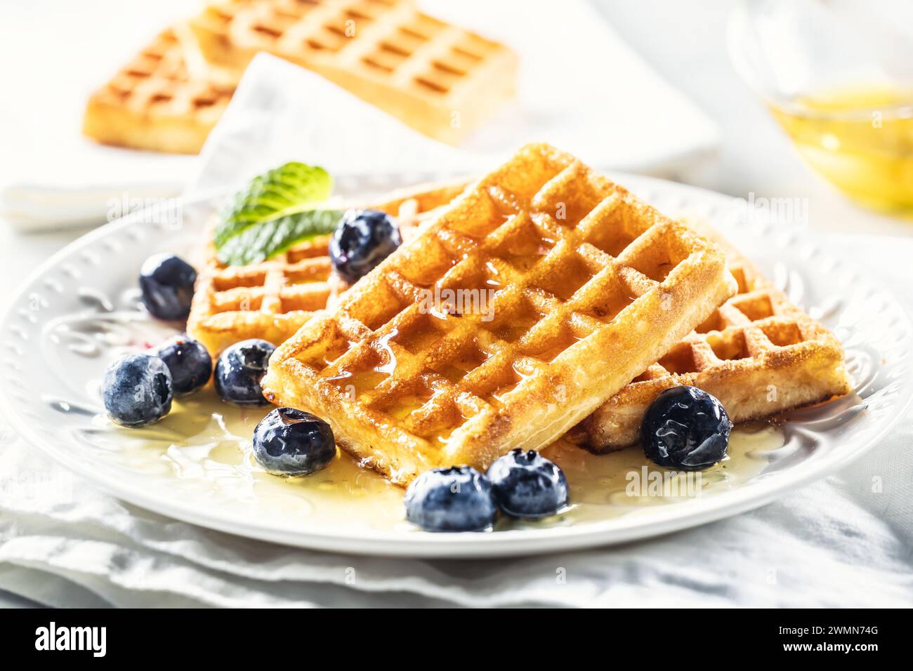 Waffle with honey and blueberries, sweet and vegan breakfast. Stock Photo