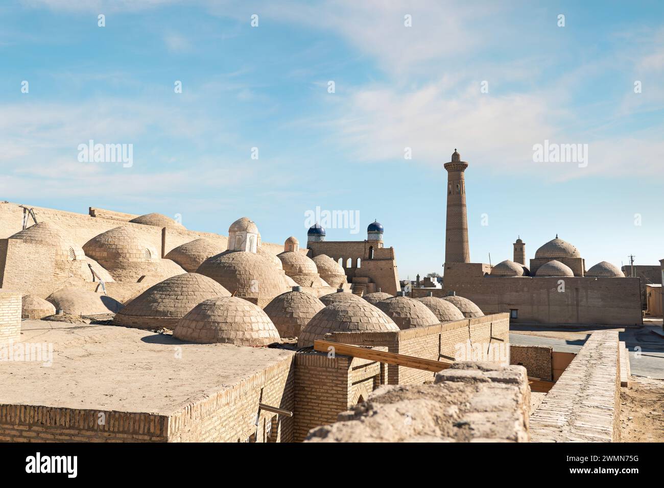 Architectural complex Palvan-darvaza of eastern gate of Ichan-Kala fortress. Domes of Anush-Khan Bathhouse, trade gallery and minaret of Sayid Niaz Sh Stock Photo