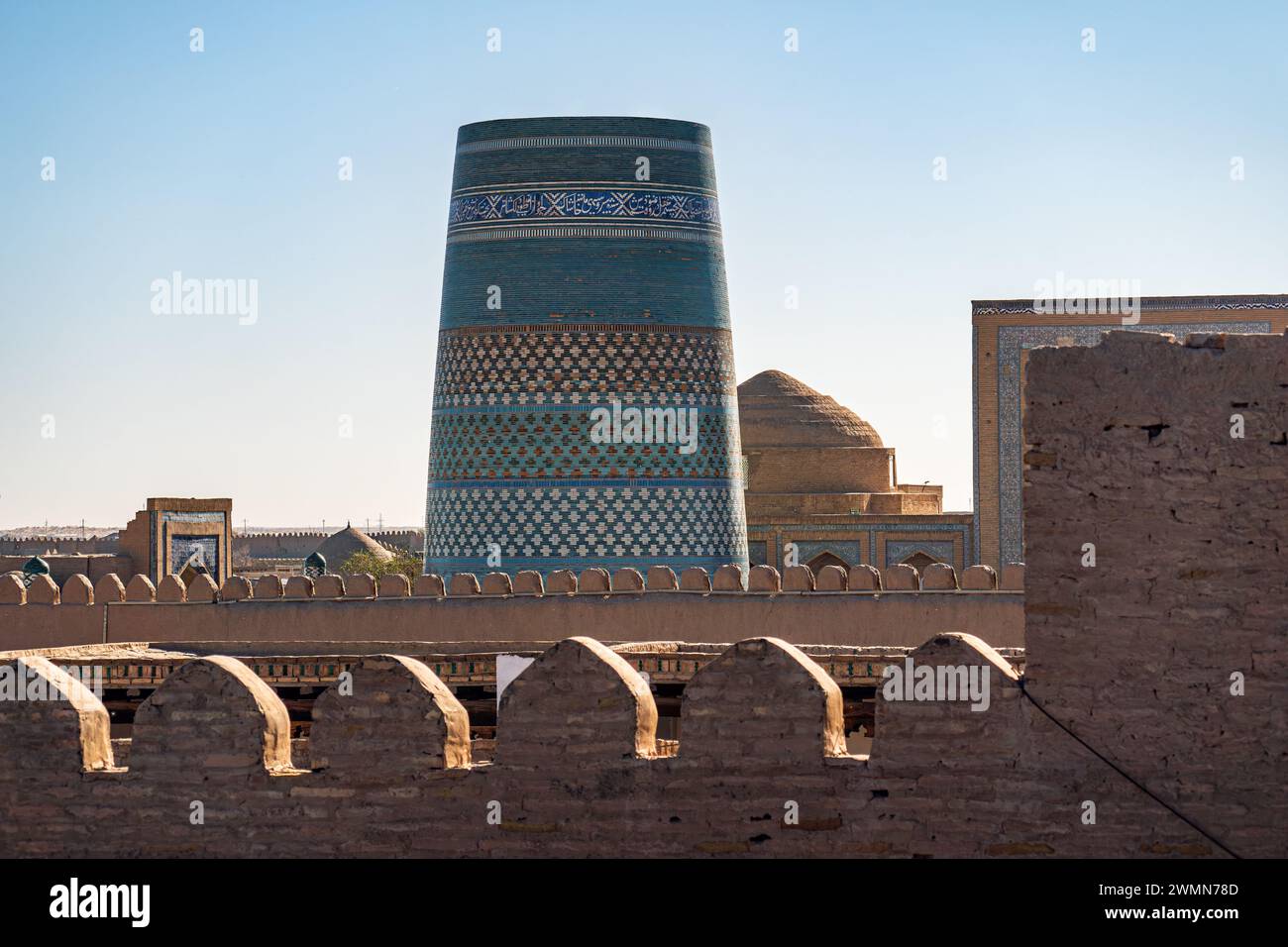 Kalta Minor is an unfinished minaret against a blue sky background located in Khiva Stock Photo