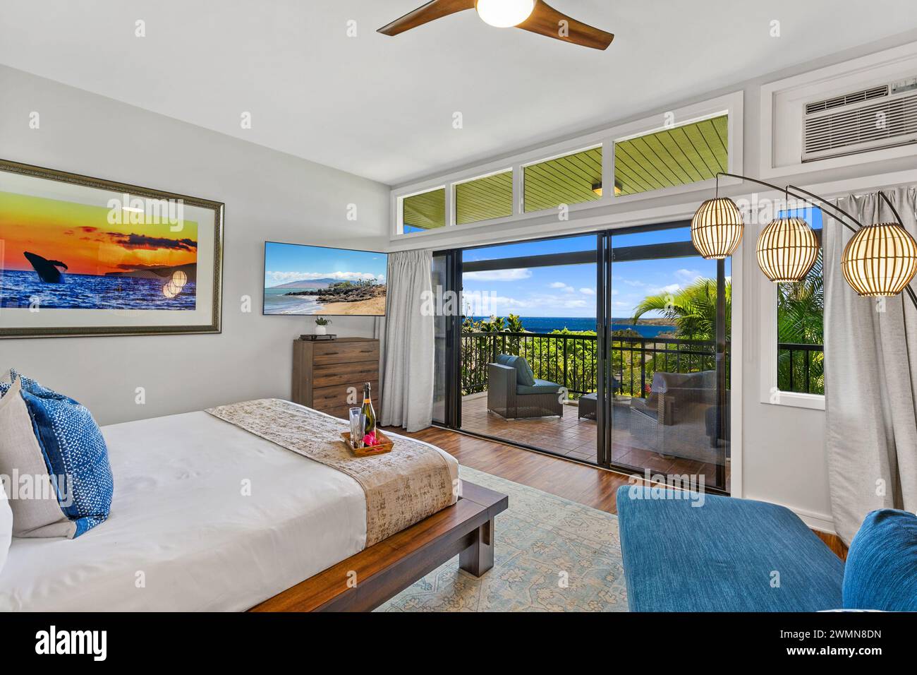 A spacious bedroom with sliding doors leading to oceanview balcony in