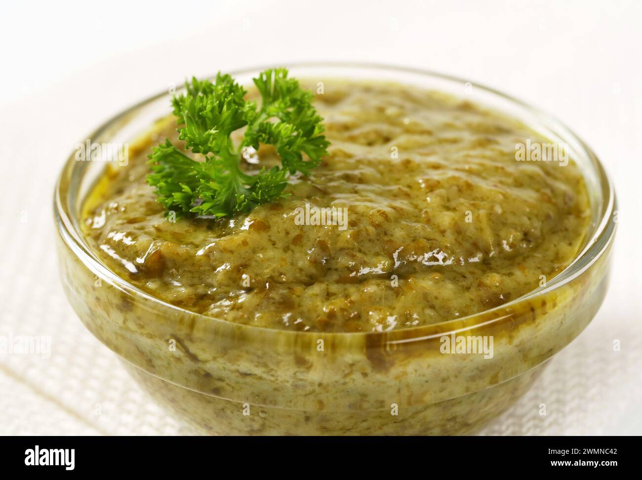 Closeup of basil pesto in glass bowl Stock Photo