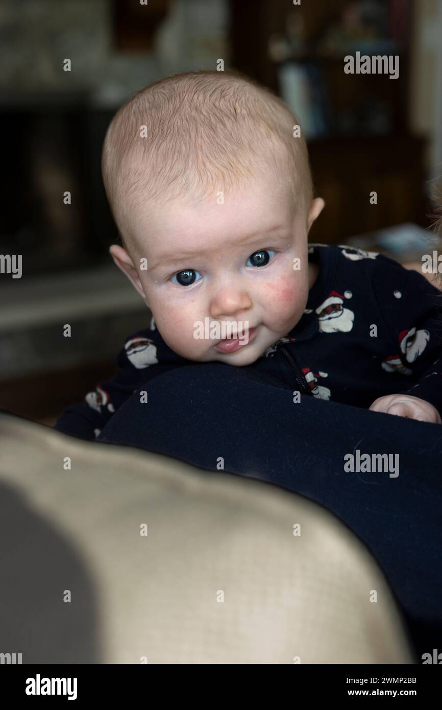 Two and a half month old baby boy looking over the back of a chair. Stock Photo