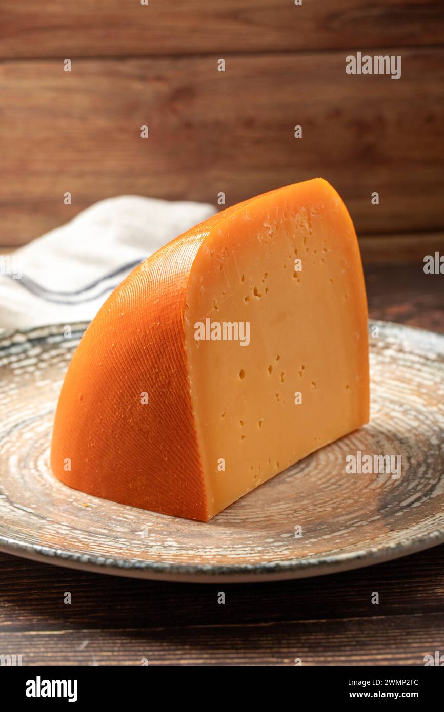 Mimolette cheese. Dairy products. Slices of Mimolette cheese on a plate. Close up Stock Photo
