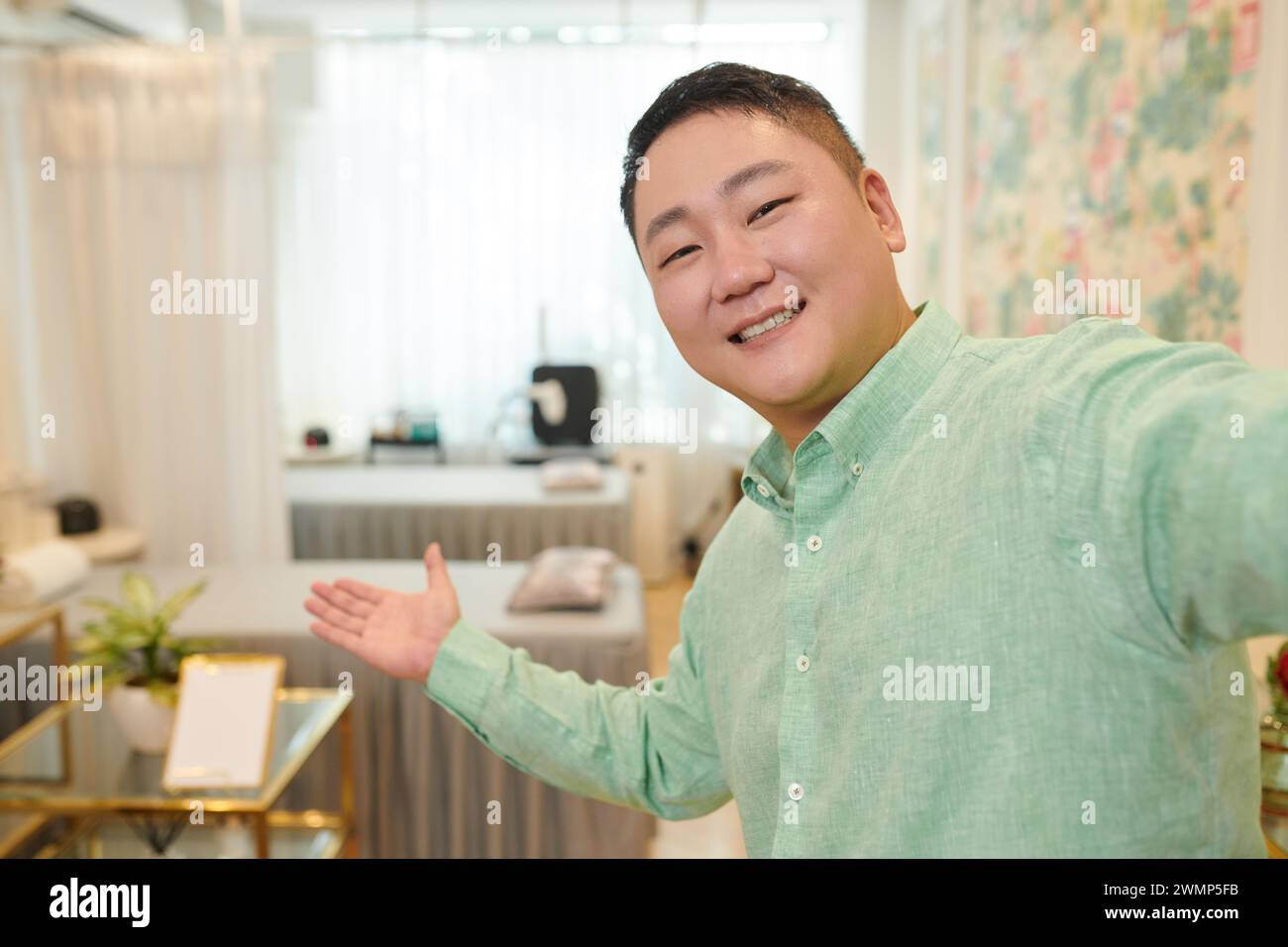 Cheerful wax salon owner filming rooms review for social media Stock Photo