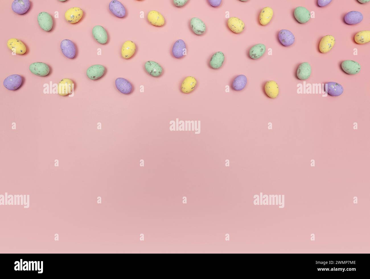 Top view of colourful easter eggs on pink background. Creative easter composition, spring, copy space, flat lay. Stock Photo