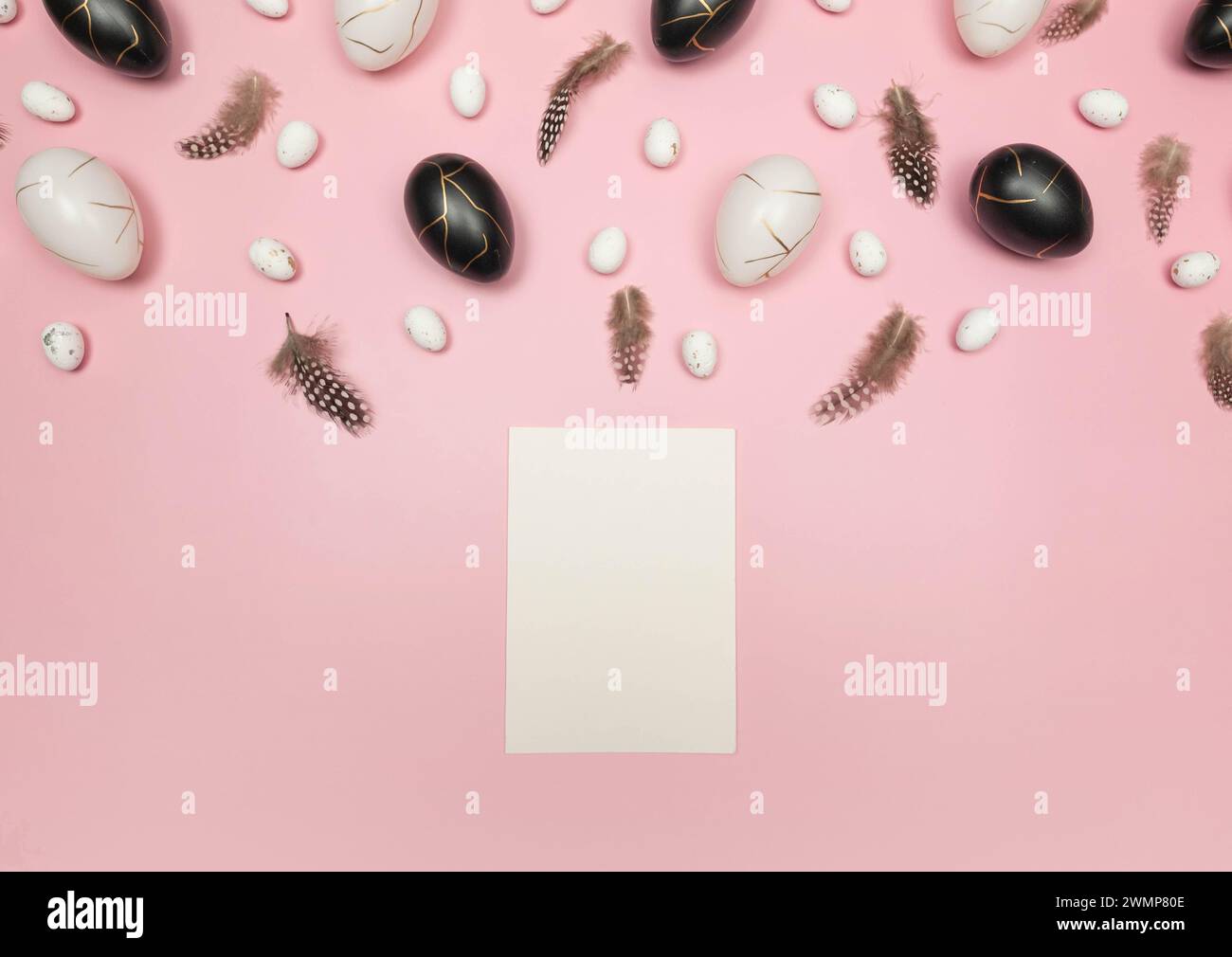 Top view of easter eggs, feathers, white card on pink background. Creative easter composition, spring, flat lay, copy space. Stock Photo