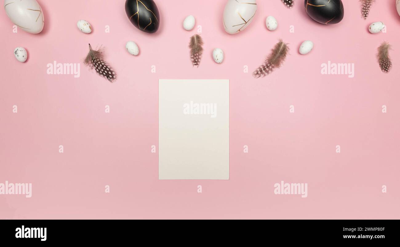 Top view of easter eggs, feathers, white card on pink background. Creative easter composition, spring, flat lay, copy space. Stock Photo