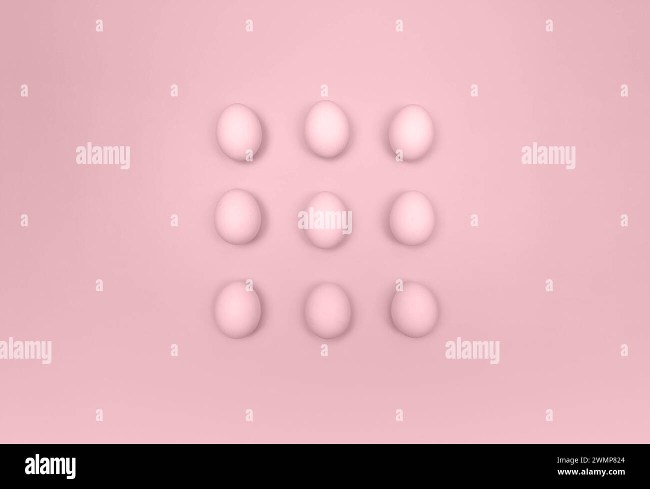 Top view of nine pink eggs on pink background. Creative easter composition, flat lay, copy space. Spring, modern and minimalist. Stock Photo