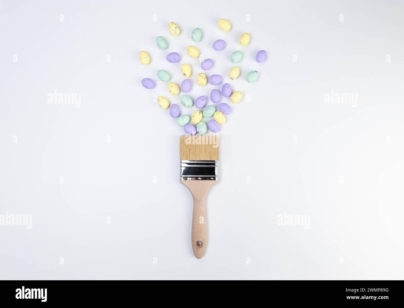 Top view of colourful easter eggs, paint brush on white background. Creative easter composition, spring, flat lay, copy space. Stock Photo