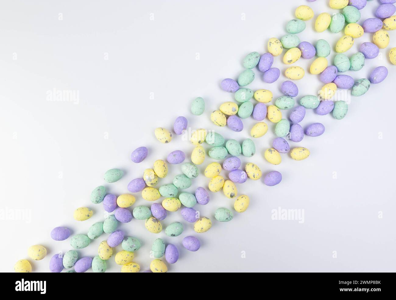 Top view of colourful easter eggs on white background. Creative easter composition, spring, copy space, flat lay. Stock Photo