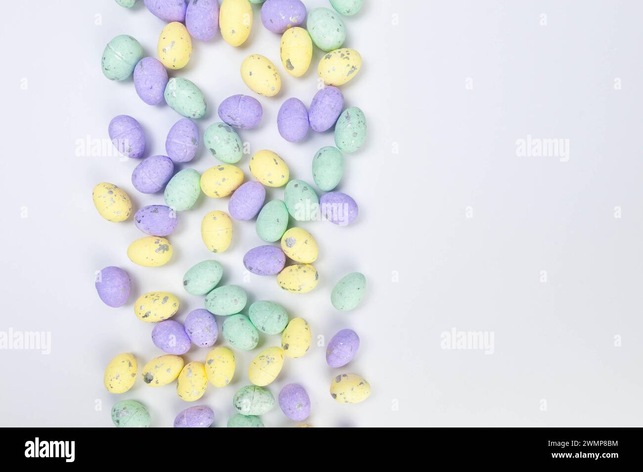 Top view of colourful easter eggs on white background. Creative easter composition, spring, copy space, flat lay. Stock Photo