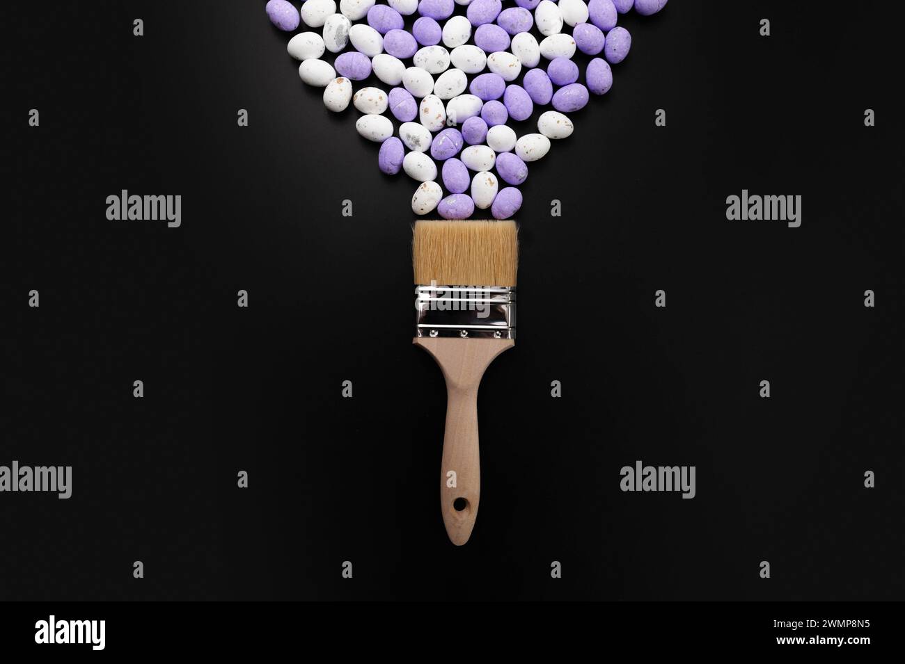 Top view of white and purple easter eggs, paint brush on black background. Creative easter composition, spring, flat lay, copy space. Stock Photo