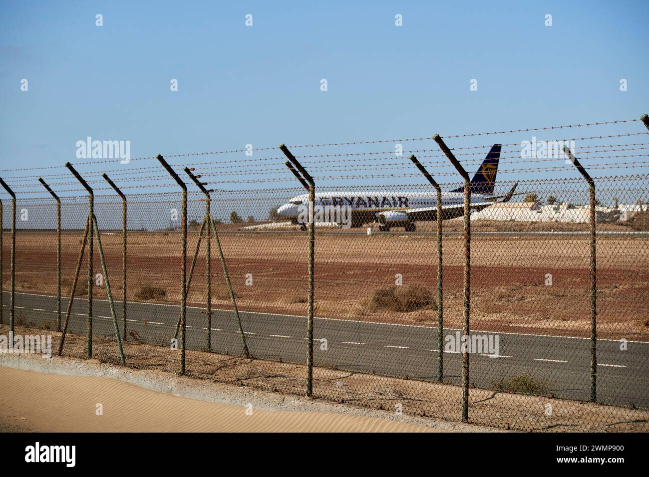 perimeter fence at ace arrecife airport with ryanair boeing 737 aircraft preparing for take off Lanzarote, Canary Islands, spain Stock Photo