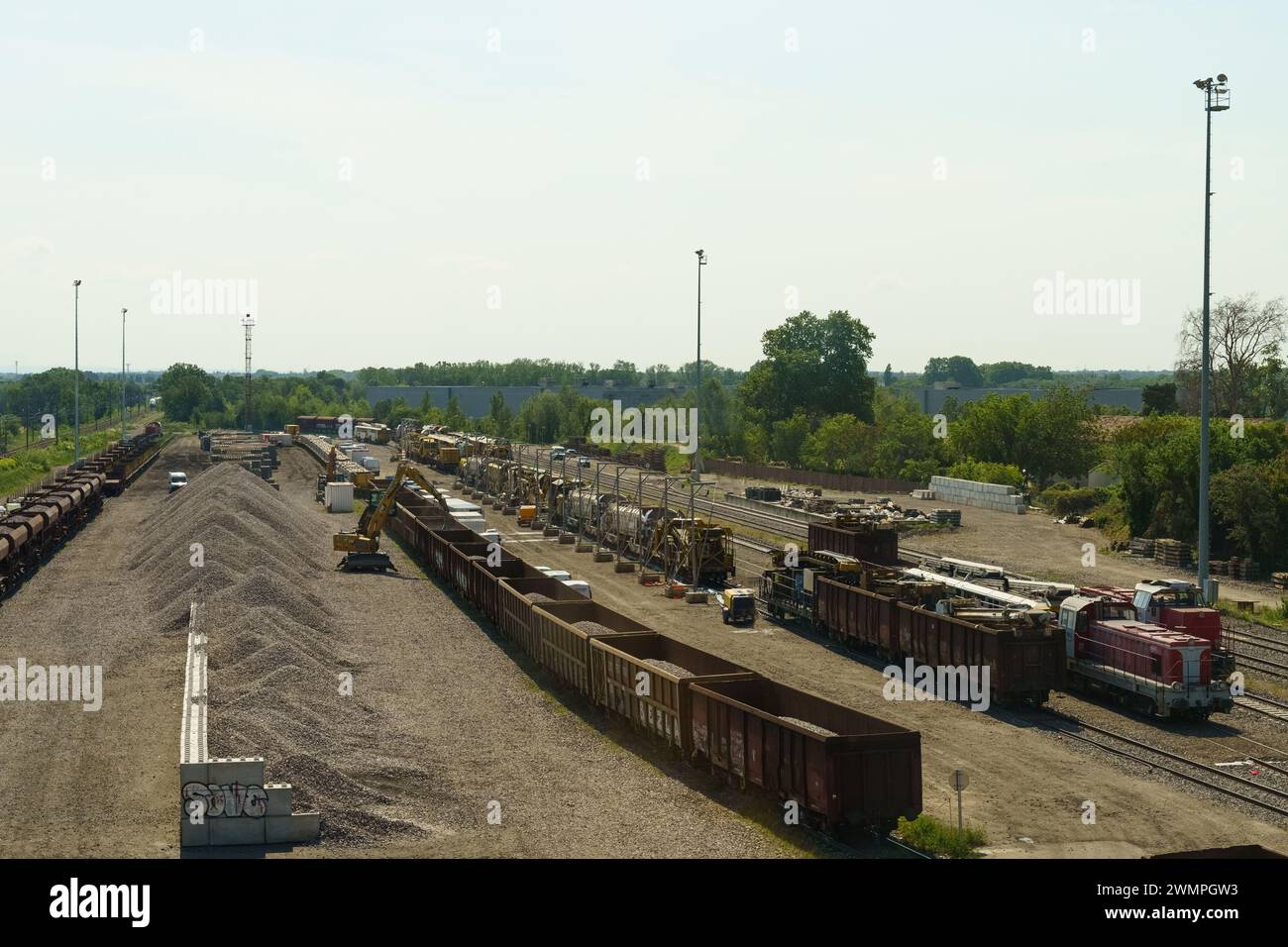Lyon, France - May 16, 2023: Multiple rows of freight trains are loaded with various goods at a sprawling train yard. The day is clear and sunny, show Stock Photo