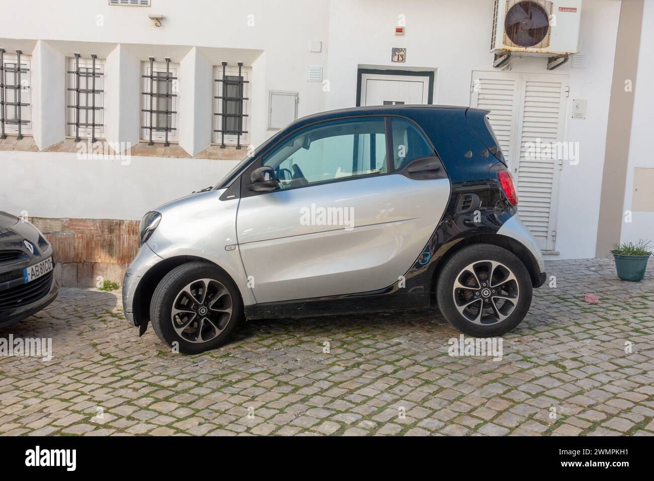 Silver And White Smart Fortwo Car Parked Outside A Home On A Hill In Old Town Albufeira Portugal, February 20, 2024 Stock Photo