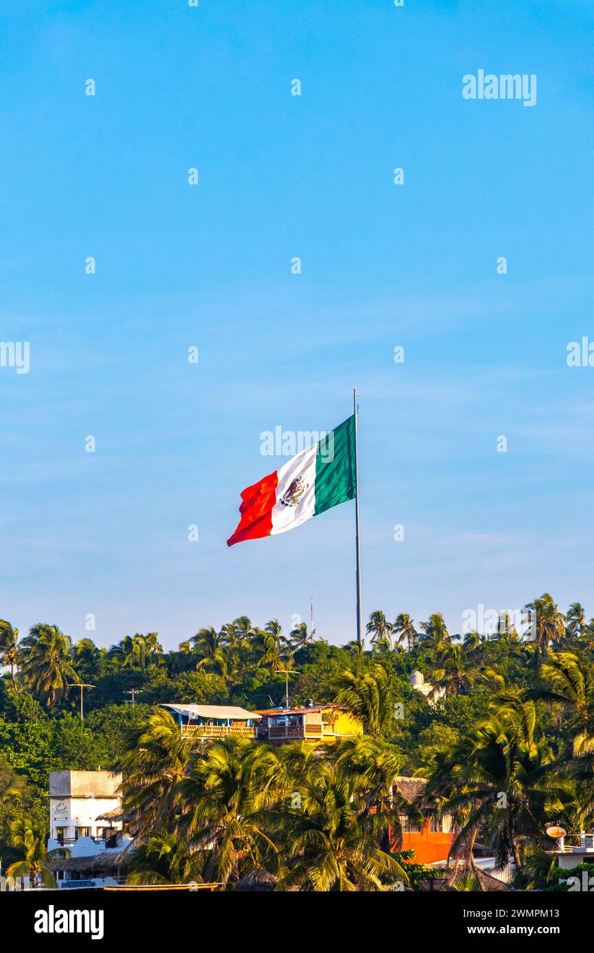 Mexican Green White Red Flag With Palm Trees And Blue Sky And Clouds In Zicatela Puerto Escondido Oaxaca Mexico. Stock Photo