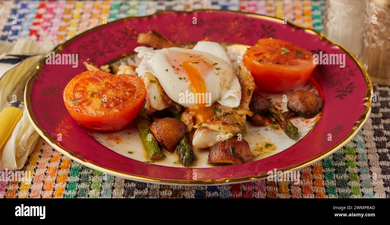 White fish fillet on a bed of mushrooms and asparagus and garnished with a poached egg. Stock Photo