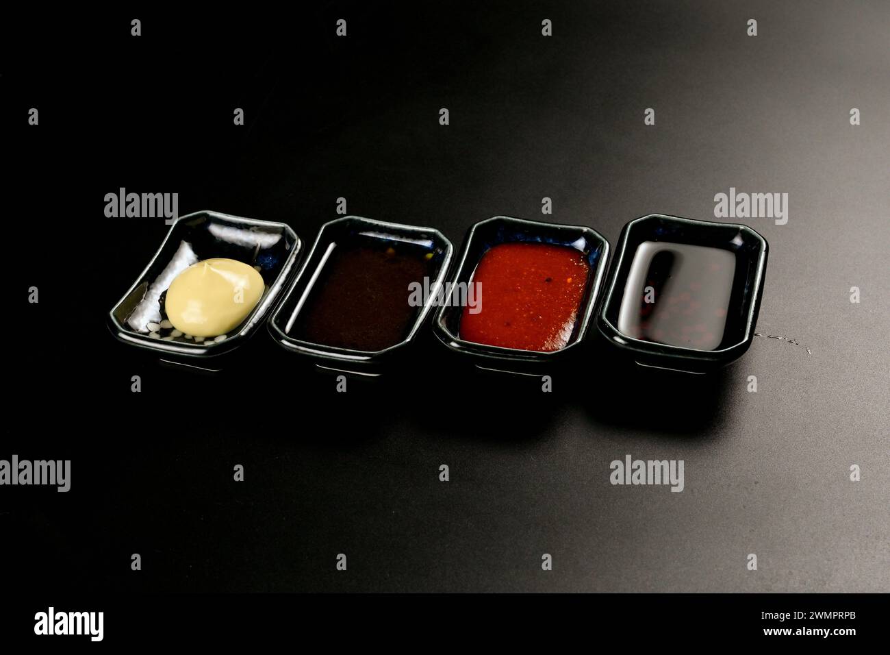 Various small containers filled with different sauces, broth, and ketchup Stock Photo