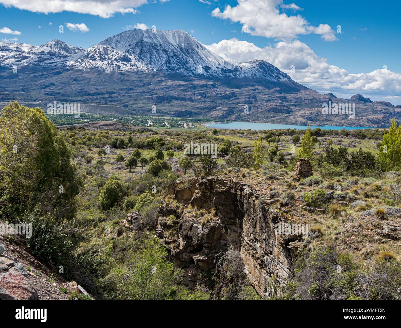 View over a canyon to village Puerto Ingeniero Ibanez located below snow-capped mountain at lake Lago General Carrera,  Patagonia, Chile Stock Photo